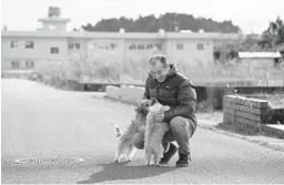  ?? KOTA ENDO/KYODO NEWS ?? Yoichi Yatsuda plays with his dogs Thursday at his home in Futaba, Japan. Until recently, the town has been deserted following a series of disasters in 2011.