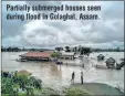  ??  ?? Partially submerged houses seen during flood in Golaghat, Assam.