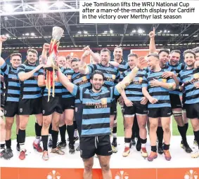  ??  ?? Joe Tomlinson lifts the WRU National Cup after a man-of-the-match display for Cardiff in the victory over Merthyr last season