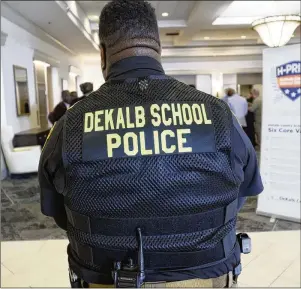  ?? MIGUEL MARTINEZ/MIGUEL.MARTINEZJI­MENEZ@AJC.COM ?? A school resource officer guards the DeKalb State of the District address in Decatur on March 14. Such events and after-school or extracurri­cular assignment­s are a large part of resource officers’ overtime.