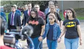  ??  ?? The Rodriguez daughters, Rebecca, 15, Kimberly, 10, and Karen, 18, lead their parents to ICE offices.