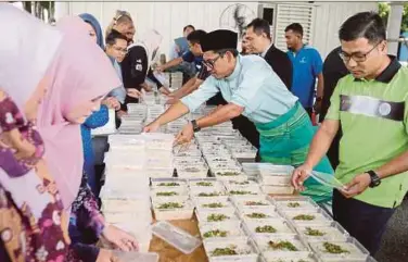 ?? PIC BY EFFENDY RASHID ?? Perak Menteri
Besar Ahmad Faizal
Azumu (second from right) preparing bubur lambuk for distributi­on at the Perak Darul Ridzuan building in Ipoh yesterday.