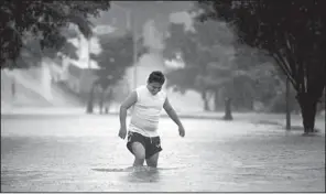  ?? AP/FELIX MARQUEZ ?? A man walks in a flooded street in Veracruz, Mexico, during heavy rains Friday caused by then-Tropical Storm Ingrid.