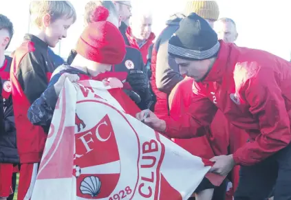  ?? ?? Sligo Rovers footballer Simon Power signs a flag for a young fan at the Super Reds Open Day at The Showground­s last Sunday.