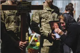  ?? LEON NEAL/GETTY IMAGES ?? Oksana Malets kisses the framed photograph of her brother, fallen soldier Igor Malets, 59, after his funeral service at Saints Peter and Paul Garrison Church on Thursday in Lviv, Ukraine.