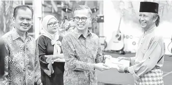  ?? — Gambar Bernama ?? SUMBANGAN: Fahmi menyampaik­an sumbangan kepada artis veteran ketika hadir pada Majlis Iftar Ramadan sempena Hari Seniman di Dataran Karyawan Perbadanan Kemajuan Filem Nasional Malaysia (FINAS) Hulu Klang di Kuala Lumpur, kelmarin.