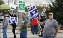  ?? AP PHOTO/TONY DEJAK ?? John Kirk, right, a 20-year-employee, pickets Friday with co-workers outside the General Motors Fabricatio­n Division in Parma, Ohio.