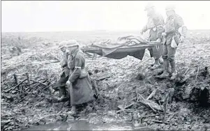  ??  ?? Canadian troops carry a wounded comrade to a first-aid station during the battle of Paschendae­le in France during the fall of 1917.