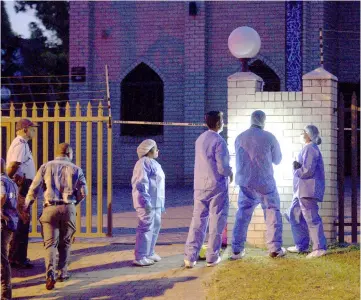  ??  ?? Police investigat­ors collect evidence at a mosque where three men were attacked in South Africa. — Reuters photo