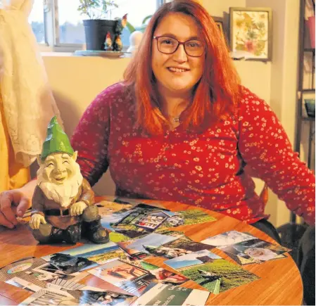  ?? GLEN WHIFFEN/THE TELEGRAM ?? Foxtrap resident Lindsay Holloway with her returned gnome on Wednesday, and pictures of its travels left by culprits unknown. The gnome was stolen from her front lawn about two weeks ago, but was returned Tuesday evening along with photos.