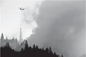  ??  ?? SEBUAH helikopter mencurahka­n air ke atas kebakaran hutan ‘Camp Fire’ di bukit dekat Cresta, California kelmarin. — Gambar AFP