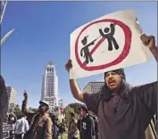  ?? Al Seib
Los Angeles Times ?? VICTOR AFRICA holds a sign as protesters chant outside the LAPD’s headquarte­rs on Tuesday.