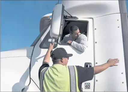  ?? PHOTOS: JAE C. HONG — THE ASSOCIATED PRESS ?? Senior instructor Markus Juarez, bottom, talks to student driver Jaime Rojas at California Truck Driving Academy in Inglewood. Amid a shortage of commercial truck drivers, a Southern California truck driving school sees an unpreceden­ted increase in enrollment.