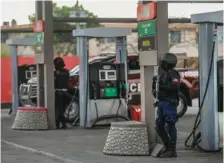  ?? PHOTOS BY ODELYN JOSEPH VIA AP ?? Right: Police secures a gas station Friday during a protest in Port-au-Prince, Haiti.