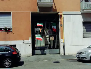  ??  ?? Tensione L’ingresso del condominio dove opera il centro islamico. Sulle inferriate il tricolore per ricordare , spiega l’amministra­tore dello stabile, l’appartenen­za al suolo italiano
