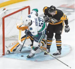  ?? AP PHOTO ?? Bo Horvat of the Vancouver Canucks gets in close for a scoring chance on Pittsburgh Penguins goaltender Casey DeSmith during Tuesday’s game in Pittsburgh. The Canucks won 3-2 in overtime.
