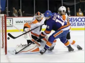  ?? FRANK FRANKLIN II — THE ASSOCIATED PRESS ?? New York Islanders’ Josh Bailey (12) shoots the puck past Philadelph­ia Flyers goalie Brian Elliott (37) for the game winning goal during the overtime period of an NHL hockey game Wednesday in New York. The Islanders won 4-3.