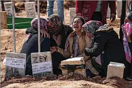  ?? EMRAH GUREL / AP ?? People mourn at the cemetery as they bury their loved ones, victims of Monday’s earthquake, in Adiyaman, Friday.