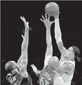  ?? Harry How Getty Images ?? KYLE KUZMA shoots over Minnesota’s Gorgui Dieng and Taj Gibson.