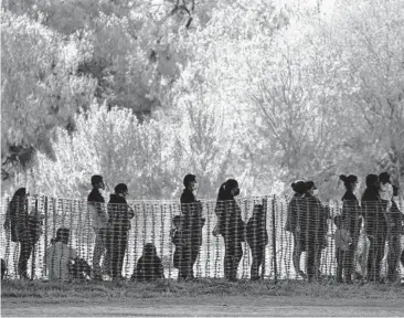  ?? JULIO CORTEZ/AP ?? Migrants are seen in custody last month at a U.S. Customs and Border Protection processing area in Mission, Texas. U.S. authoritie­s picked up a record 18,663 children traveling alone across the Mexican border in March.