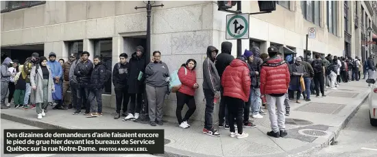  ?? PHOTOS ANOUK LEBEL ?? Des dizaines de demandeurs d’asile faisaient encore le pied de grue hier devant les bureaux de Services Québec sur la rue Notre-Dame.