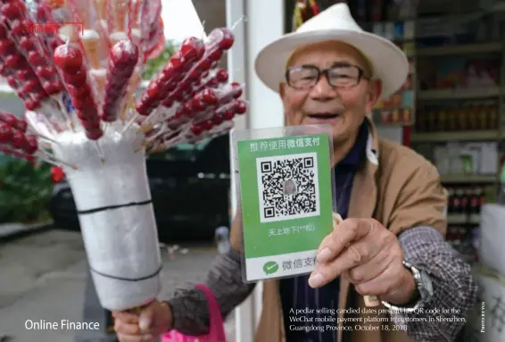  ??  ?? A pedlar selling candied dates presents his QR code for the Wechat mobile payment platform to customers in Shenzhen, Guangdong Province, October 18, 2018