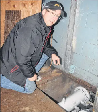  ??  ?? Trenton rink manager Darryl Marcott demonstrat­es the spot where a pipe burst on Friday, causing the rink to shut down for the weekend.