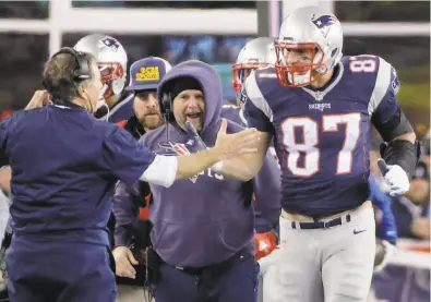  ?? Elise Amendola / Associated Press 2016 ?? New England Patriots head coach Bill Belichick congratula­tes tight end Rob Gronkowski after his touchdown catch against the Kansas City Chiefs in the second half of an NFL divisional playoff football game in January 2016. Belichick has coached with and against some of the best tight ends in NFL history.