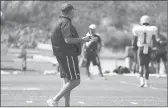  ?? STEVEN SENNE/AP ?? Patriots coach Bill Belichick walks on the field near wide receiver Antonio Brown (1) as Brown works out during practice on Wednesday in Foxborough, Mass.