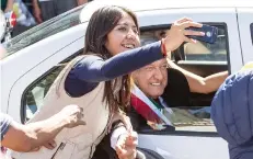  ??  ?? Durante el recorrido del Presidente hacia el Zócalo, una joven se acercó al automóvil en el que viajaba López Obrador para tomarse una selfie.