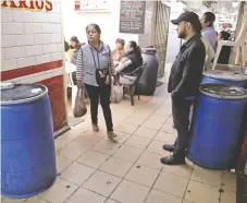  ??  ?? En el mercado de Constituci­ón de 1917, en Iztapalapa, los locatarios de negocios de comida guardaron agua en varios tambos.