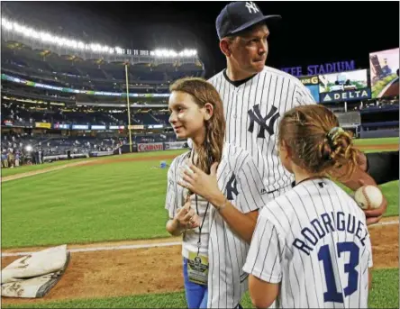  ?? KATHY WILLENS — THE ASSOCIATED PRESS ?? New York Yankees designated hitter Alex Rodriguez (13) gathers his daughters, Natasha, left, and Ella, before leaving the field after his final baseball game as a Yankee player, against the Tampa Bay Rays at Yankee Stadium in New York, Aug. 12.