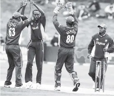  ?? FILE ?? West Indies players in Digicel-branded outfits (from left) Darren Ganga, Ian Bradshaw, Denesh Ramdin and Shiv Chanderpau­l celebrate a wicket during a One-day Internatio­nal against New Zealand in 2006.