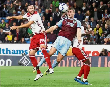  ?? — Reuters ?? Sandwiched: Burnley’s Sam Vokes heads at goal during the Europa League qualifier against Olympiakos on Thursday.