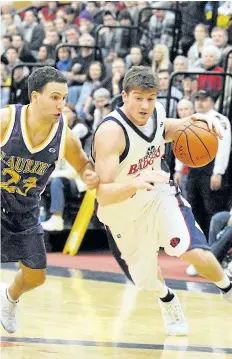  ?? FILE PHOTO ?? A.N. Myer graduate Mike Kemp, right, shown dirving the ball past Laurier in men's university basketball in this file photo, is being inducted into the Niagara Falls high school's Wall of Distinctio­n.