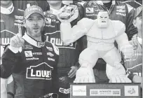  ??  ?? Jimmie Johnson poses with a trophy in Victory Lane after he won Sunday’s NASCAR Cup series race at Dover Internatio­nal Speedway in Dover, Del.