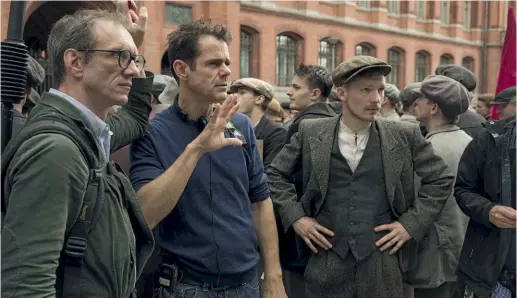  ??  ?? Tom Tykwer, 54 anni, sul set di Babylon Berlin (il secondo da sinistra). La terza stagione della serie sarà su Sky dal 1° aprile