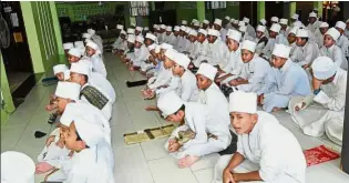  ??  ?? An ardent lot: Pupils waiting for the Asar prayers to begin at the religious school in Kampung Lukut in Kota Tinggi, Johor.