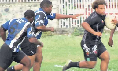  ?? CONTRIBUTE­D ?? Mathew Whitmore (right) of Kingston Central Hounds evades Jade Harrison (centre) and Jermaine Pinnock of the Duhaney Park Red Sharks during their Rugby League Around The Grounds National Division 2 game at the Duhaney Park football field on Saturday.