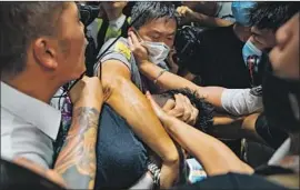  ?? Anthony Kwan Getty Images ?? AT THE Hong Kong airport, demonstrat­ors confronted two men suspected of being mainland police. Above, a suspected undercover officer is surrounded.