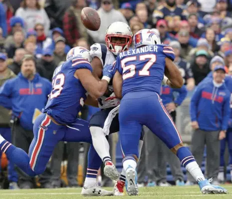  ?? ADRIAN KRAUS/THE ASSOCIATED PRESS ?? Buffalo Bills linebacker­s Matt Milano, left, and Lorenzo Alexander break up a pass intended for the New England Patriots’ James White, centre, on Sunday.