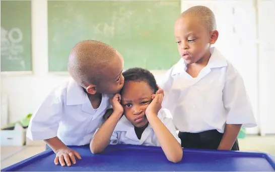  ?? Picture: Michel Bega ?? BROTHERLY LOVE. Tumelo, left, and Tumisang console sister Reitumetse, after their first day at Totomeng Primary School in Meadowland­s, Soweto. The four-year-old Mosito triplets started their school year yesterday.