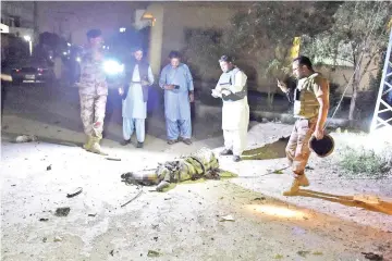  ?? — AFP photos ?? Pakistani security personnel gather beside the body of a militant following an attack on the paramilita­ry Frontier Corps (FC) office in Quetta.