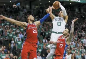  ?? ELISE AMENDOLA — THE ASSOCIATED PRESS ?? Boston Celtics forward Jayson Tatum goes up for a shot over the Sixers’ Ben Simmons, left, and J.J. Redick in the second half of Game 1 of the Eastern Conference semifinal series between the teams Monday night at TD Garden.