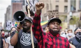  ?? Photograph: Ira Black/Getty Images ?? Derrick Ingram, in red, was charged with felony assault in the second degree in June, after he allegedly shouted in a police officer’s ear with a loudspeake­r at a protest.