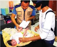  ?? ADI WIJAYA/JAWA POS ?? IDENTIFIKA­SI: Tim identifika­si Satreskrim Polres Gresik memeriksa bayi yang dibuang ibunya di Desa Randegansa­ri, Driyorejo.