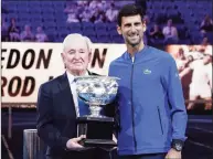  ?? Aaron Favila / Associated Press ?? Novak Djokovic, right, presents a trophy to Rod Laver during the 50th anniversar­y celebratio­n for the Australian Open and Laver’s second Grand Slam at the Australian Open tennis championsh­ips in Melbourne in 2019.