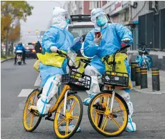  ?? Photos: AFP, Simon Song ?? Workers carry equipment for testing on a street in Beijing, one of the cities that has seen unrest over Covid-19 policies.