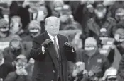  ?? CARLOS OSORIO AP ?? President Donald Trump gestures to supporters Tuesday in Lansing, Michigan, one of three campaign stops he made.