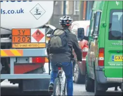  ??  ?? Cyclists battle heavy traffic